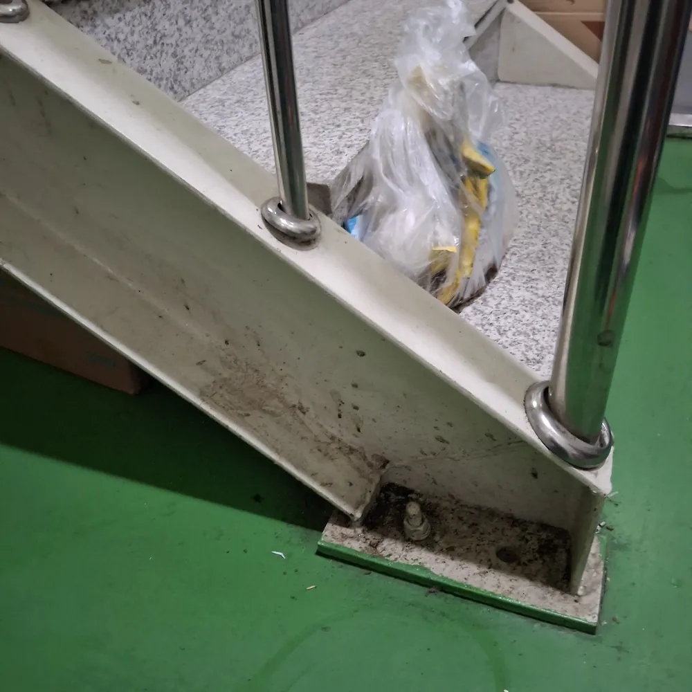 공동현관 문틀 하부와 스테인리스 기둥 밑동에 검은 흙먼지가 눌어붙어 있는 상태